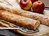 Two whole apple strudels with powdered sugar