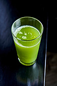 An apple, cucumber and celery smoothie in a glass