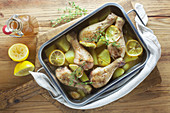 Lemon chicken in a baking dish on a wooden surface