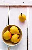 Pears in a bowl on a wooden background (top view)