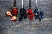 Strawberries, blackberries, raspberries and blueberries on spoons