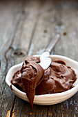 Chocolate hazelnut spread on a rustic wooden surface