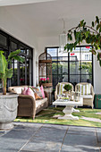 Wicker furniture and leaf-patterned rug on roofed terrace