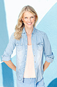 Junge blonde Frau in Jeanshemd mit hellem Top