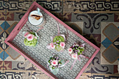 Small posies on tray on old tiled floor