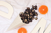 A paper cone with chocolate orange popcorn (seen from above)
