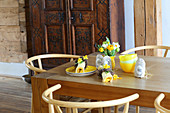 Yellow crockery, Easter wreaths on napkins, sachets with rabbit motifs and posy of flowers