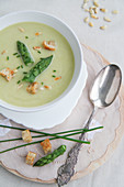 Cream of asparagus soup with croutons and pine nuts