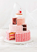 Aus verschiedenen Kuchen zusammengesetzte, prunkvolle Torte mit Cupcake-Krone