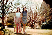 Zwei junge Frauen in sommerlichen Outfits im Park