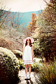 A young woman wearing a summer hat and a white dress