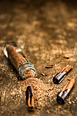 Cinnamon sugar in a narrow jar, with cinnamon sticks dipped in chocolate