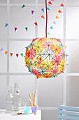Paper lampshade covered in cocktail umbrellas as party decoration