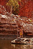 A young woman standing on rocks wearing a summer dress