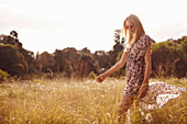 Junge blonde Frau im Sommerkleid in der Natur