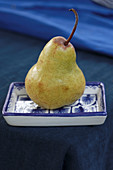 Pear in blue and white dish on blue tablecloth