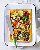 A vegetable tart with roasted vegetables and herb oil