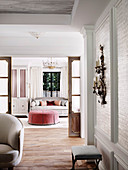 Stool under antique wall lamp, living room with ottoman in the background