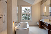 Freistehende Badewanne an Raumteilerwand im modernen Bad
