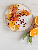 Halved bananas with oranges, grapefruit and pomegranate seeds