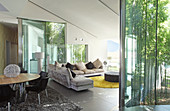 Modernes Wohnzimmer mit Glaswänden zum Bambusgarten