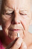 Elderly woman taking a pill