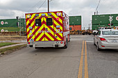 Ambulance waiting at level crossing, USA