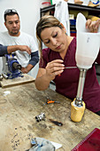 Disabled worker making prosthetic leg, Mexico