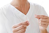 Woman holding acupuncture needles