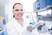 Lab assistant holding chemical flask