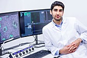 Scientist in laboratory with computer monitors