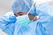 Male surgeon putting on surgical mask