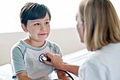 Boy looking towards nurse with stethoscope