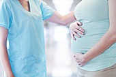 Pregnant woman with nurse, cropped view
