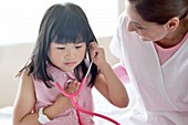 Girl using stethoscope with nurse