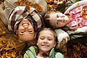 Family lying down on Autumn leaves