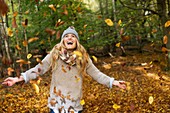 Woman playing in Autumn leaves