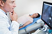 Doctor looking at screen with hand on chin