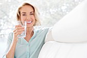 Mature woman smiling with glass of water