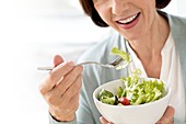 Mature woman eating salad