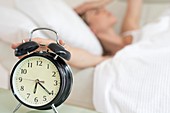 Woman touching alarm clock