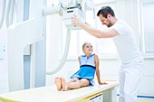 Doctor preparing girl for x-ray in hospital