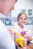 Girl with arm brace holding teddy bear