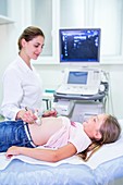 Sonographer performing ultrasound on girl