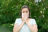 Woman blowing her nose on a tissue