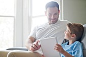 Boy using tablet with his father