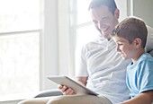 Boy using tablet with his father