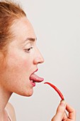Woman testing heat of chili with her tongue