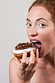 Woman eating chocolate doughnut
