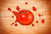 Tomato and ketchup on wooden board